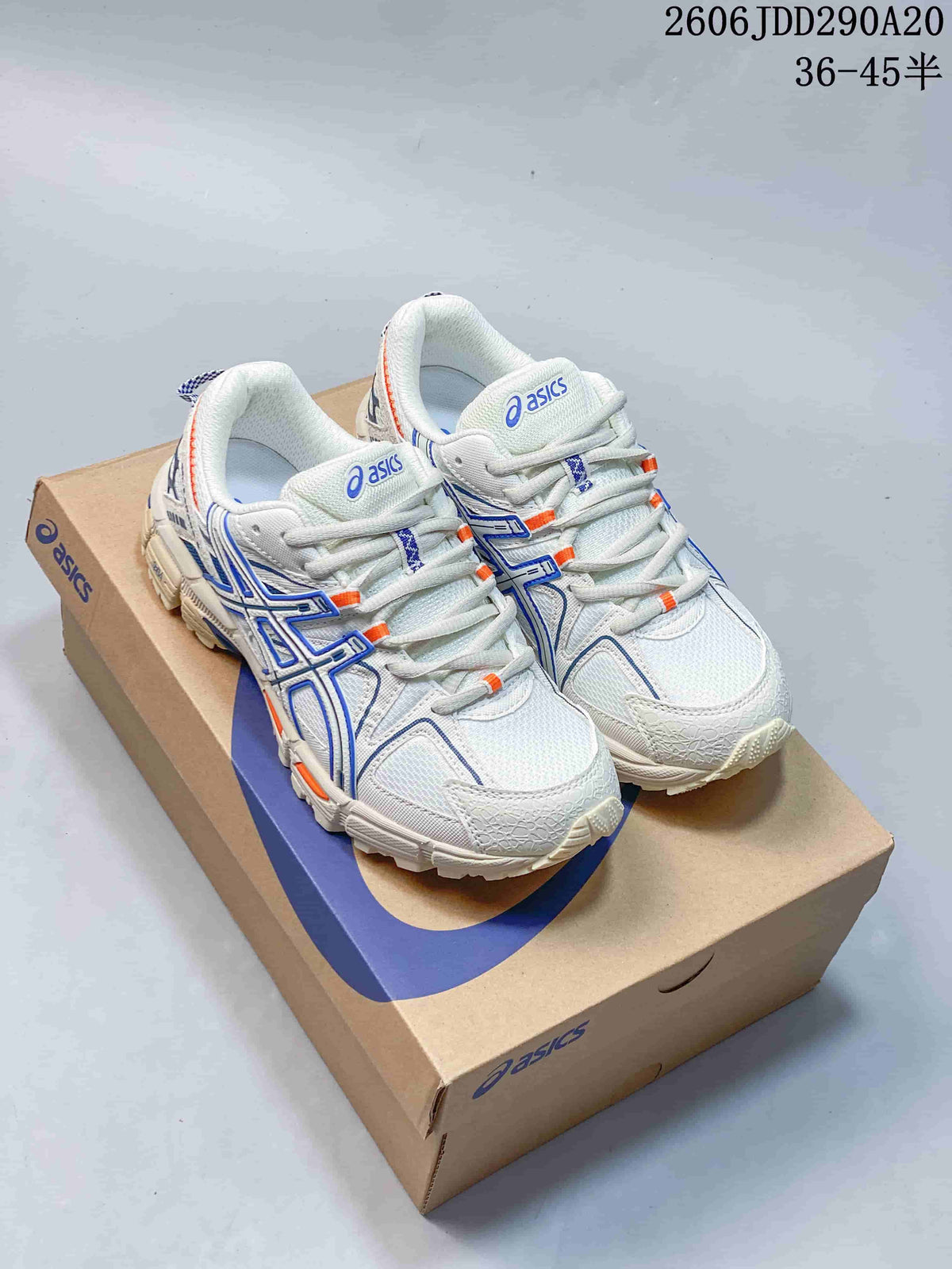 Pair of white ASICS Gel-Kahana 8 sneakers with blue and orange accents on a shoebox.