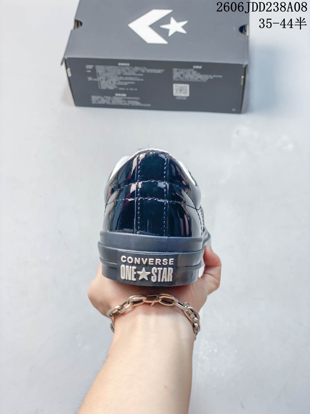 Rear view of a glossy navy Converse One Star sneaker showing heel branding