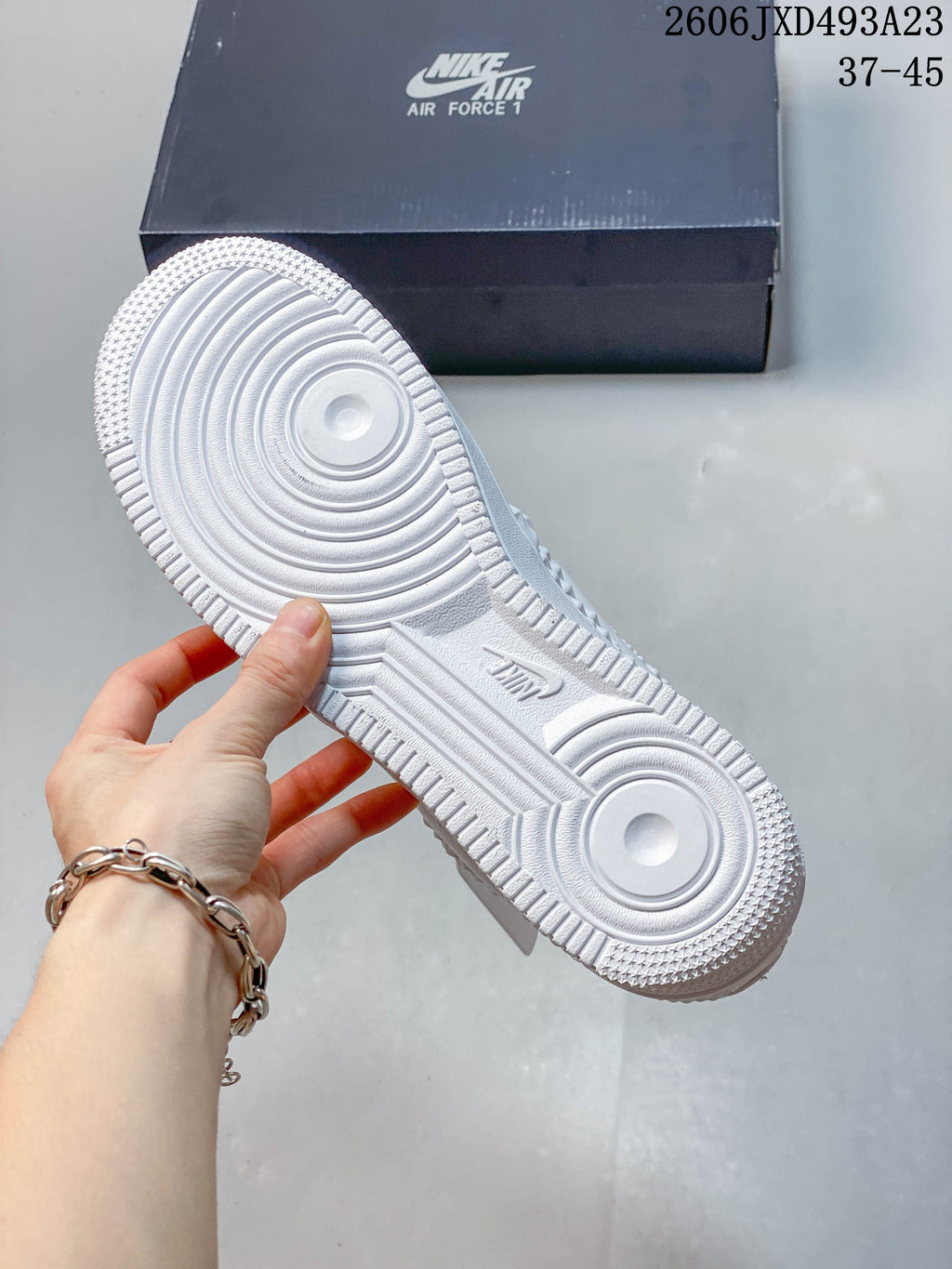 Underside of the white sneaker showing a circular-patterned outsole