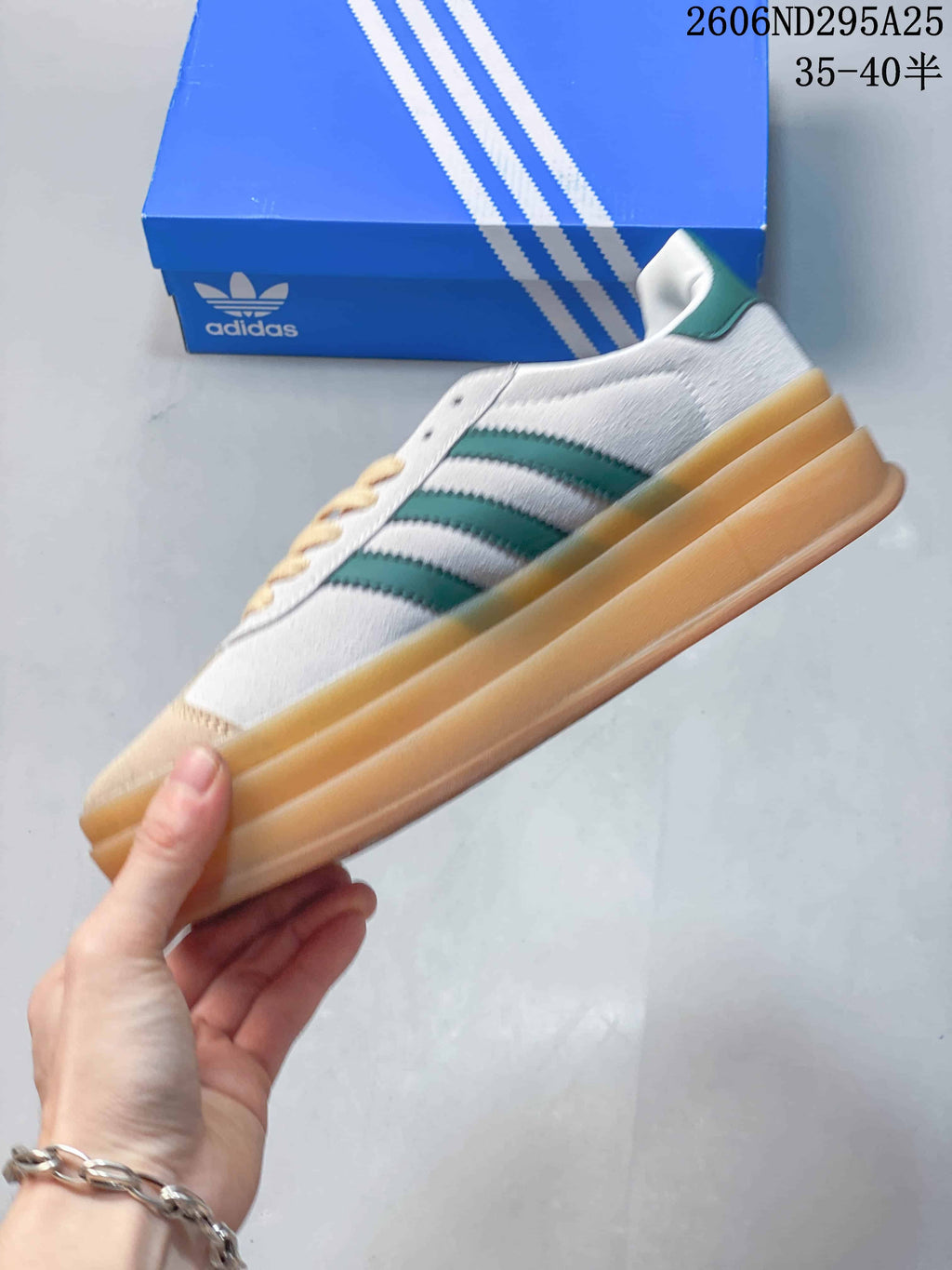 Side view of the sneaker with green stripes and a raised gum-colored sole.