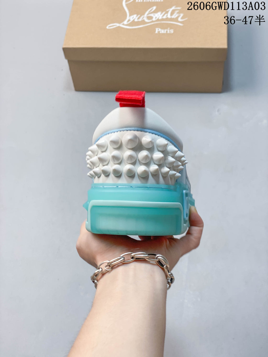 Rear view showing studded heel detailing, red heel tab, and turquoise-colored sole