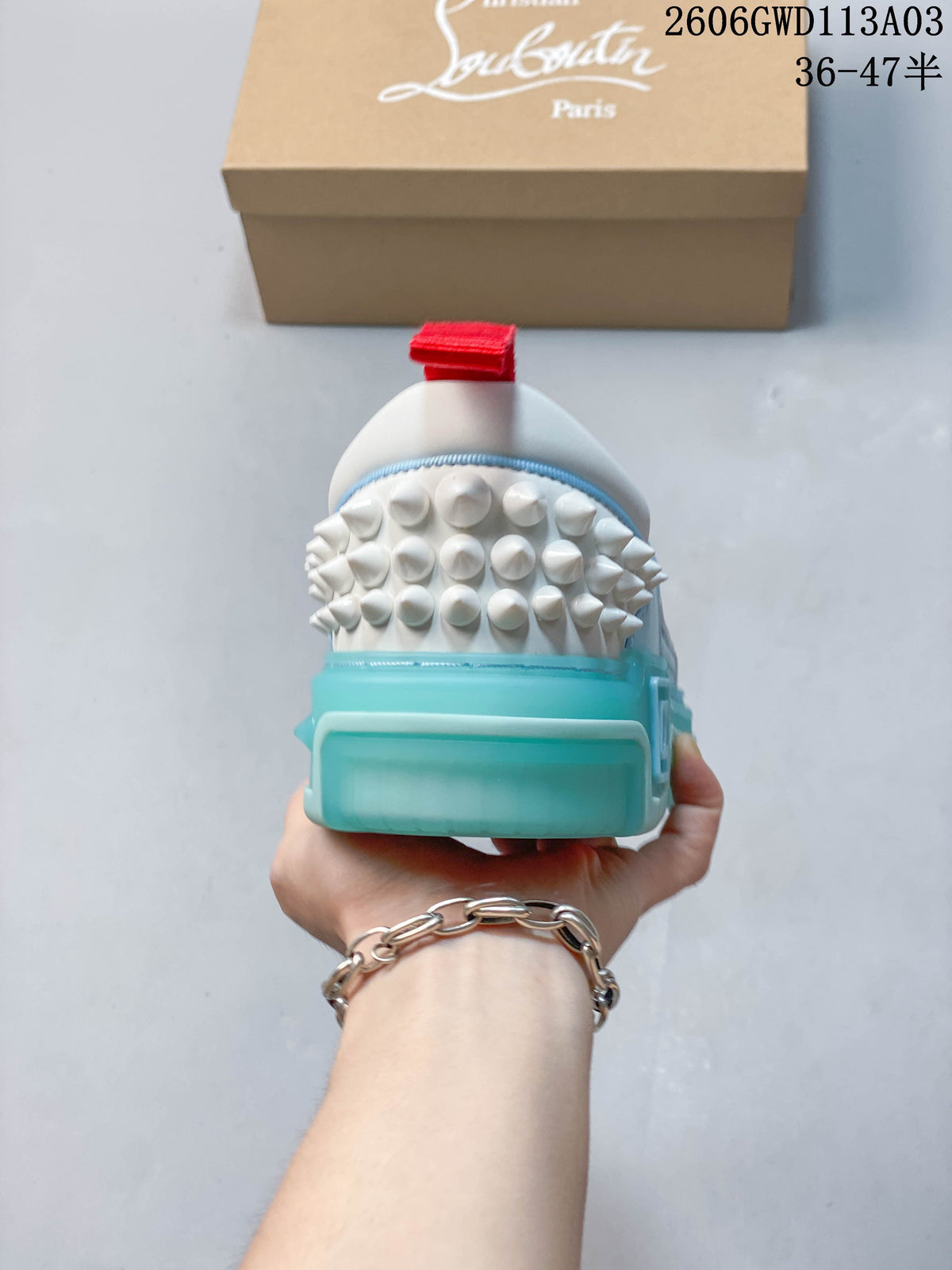 Rear view showing studded heel detailing, red heel tab, and turquoise-colored sole