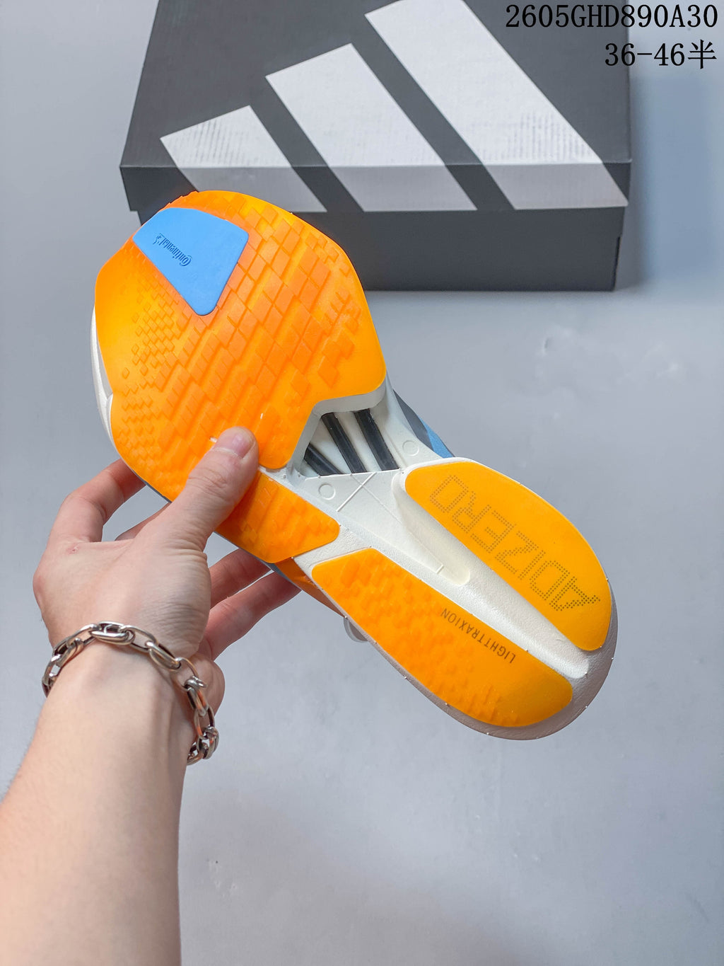 Underside of the shoe showing an orange outsole with blue and white sections