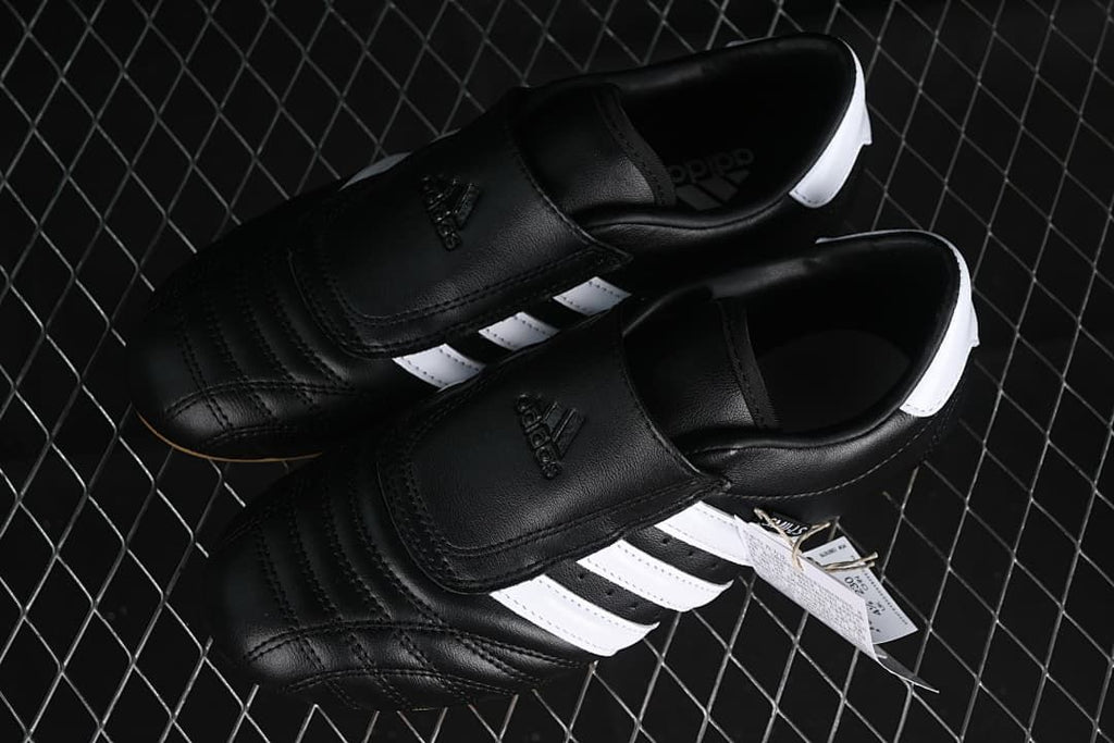 Pair of black and white Adidas Taekwondo sneakers shown from above.