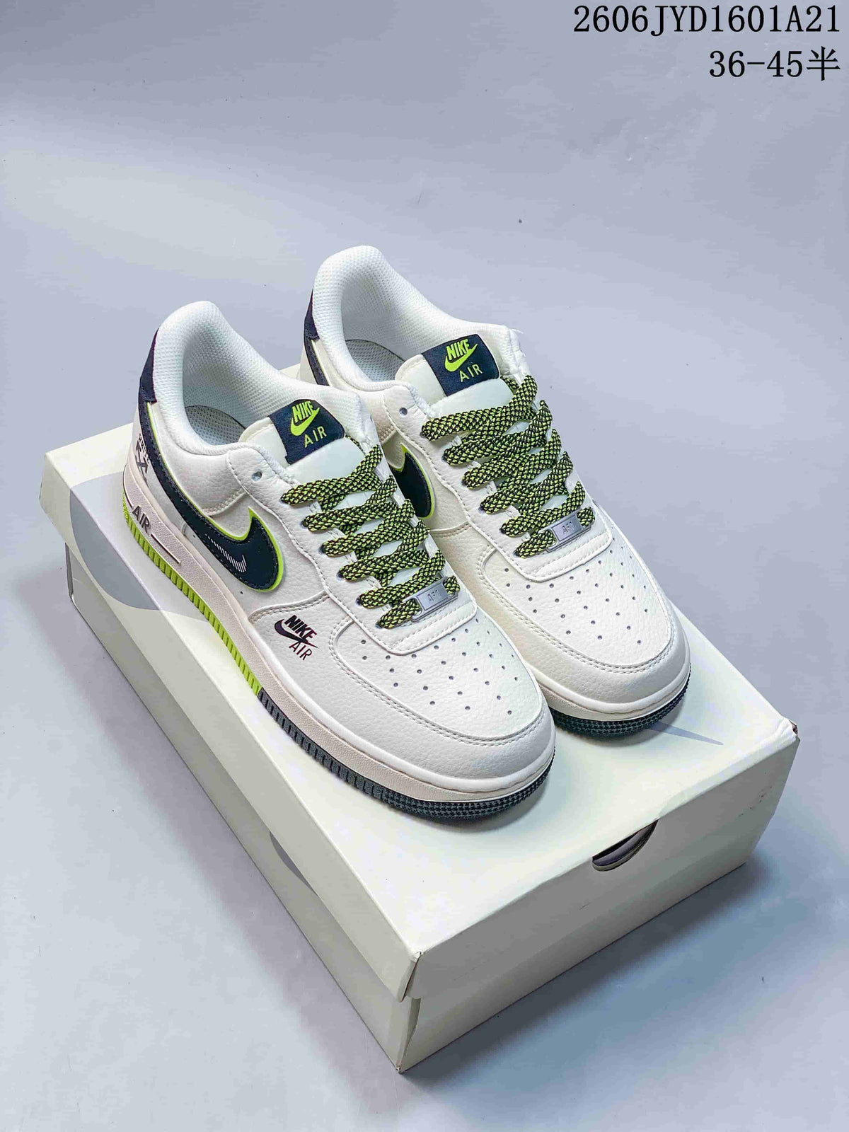 Pair of white low-top sneakers with navy and lime accents, patterned laces, and a box