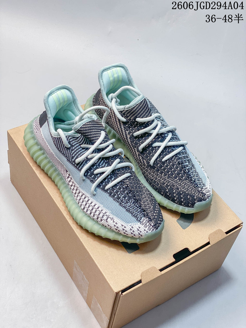 Pair of blue-gray Adidas Yeezy Boost 350 V2 sneakers with pale aqua ribbed soles