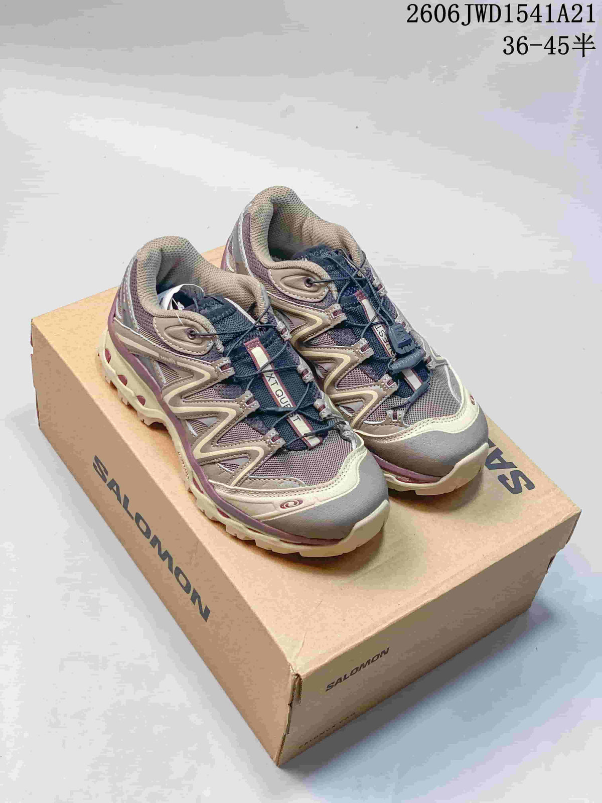 Pair of gray and mauve Salomon XT-Quest ADV shoes displayed on a branded box