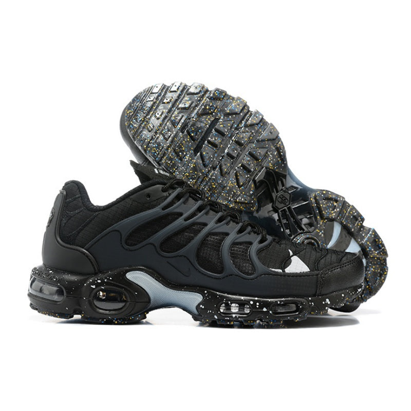 Black Nike Air Max Plus sneakers shown from the side and outsole with a speckled finish.