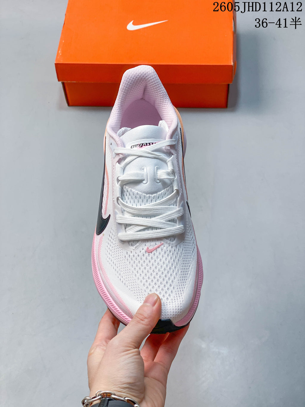 Front view of the white and pink running shoe with white laces.