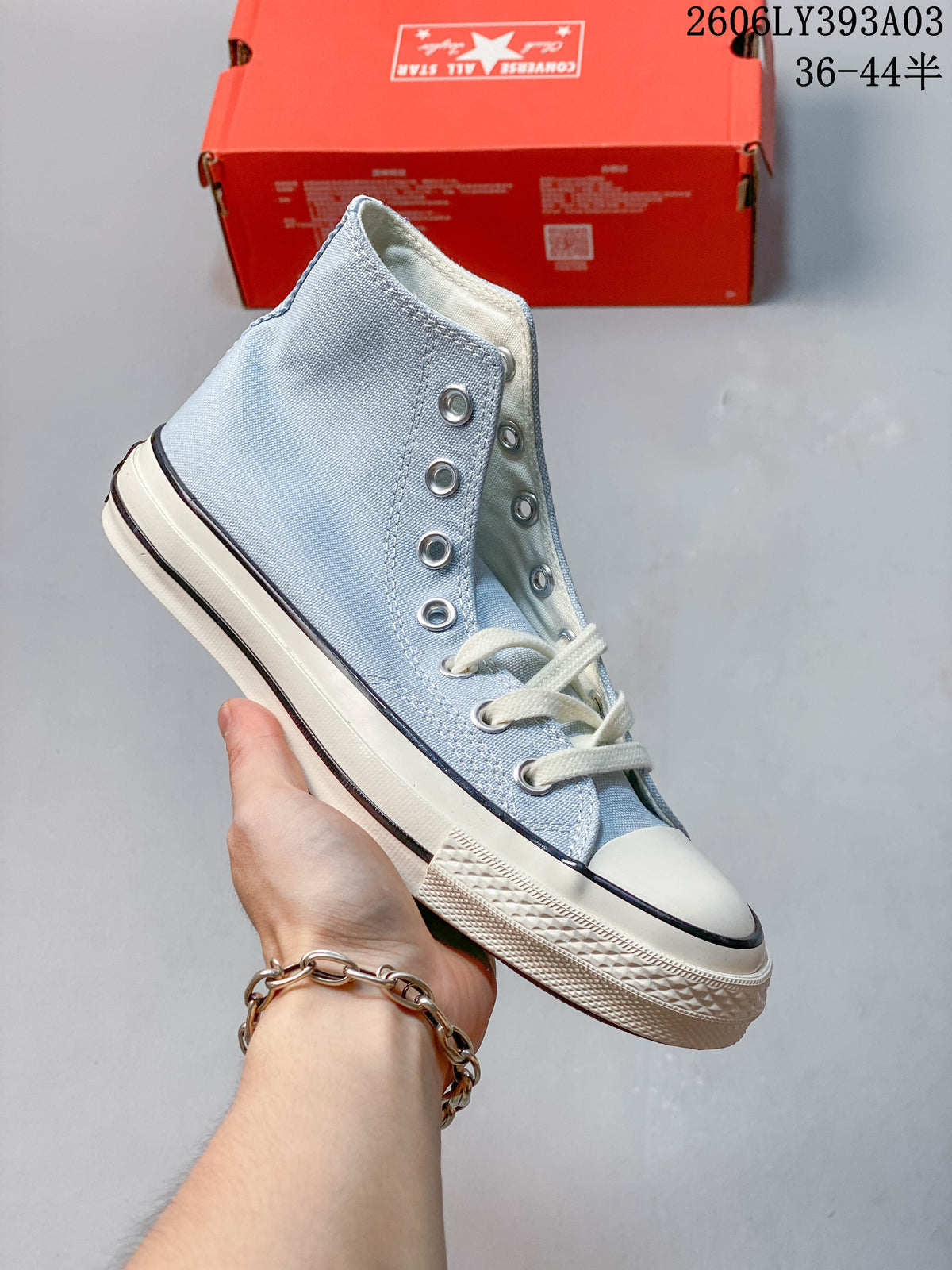 Light blue high-top Converse-style sneaker with white laces and rubber toe cap