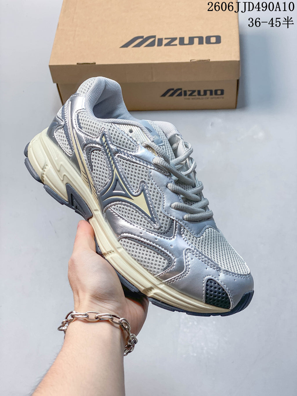 Silver and white mesh Mizuno sneaker with dark blue accents and a cream-colored sole.