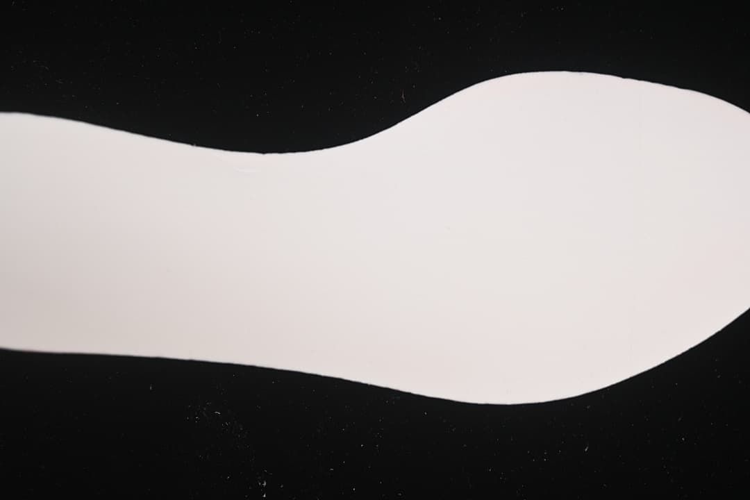 White shoe insole shown separately against a dark background