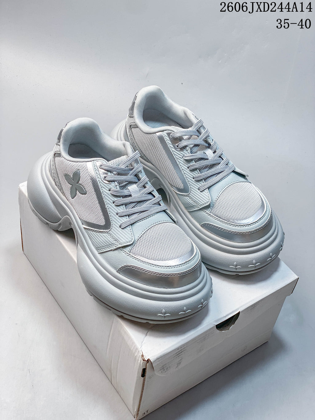 Pair of pale gray SMFK sneakers shown from the front