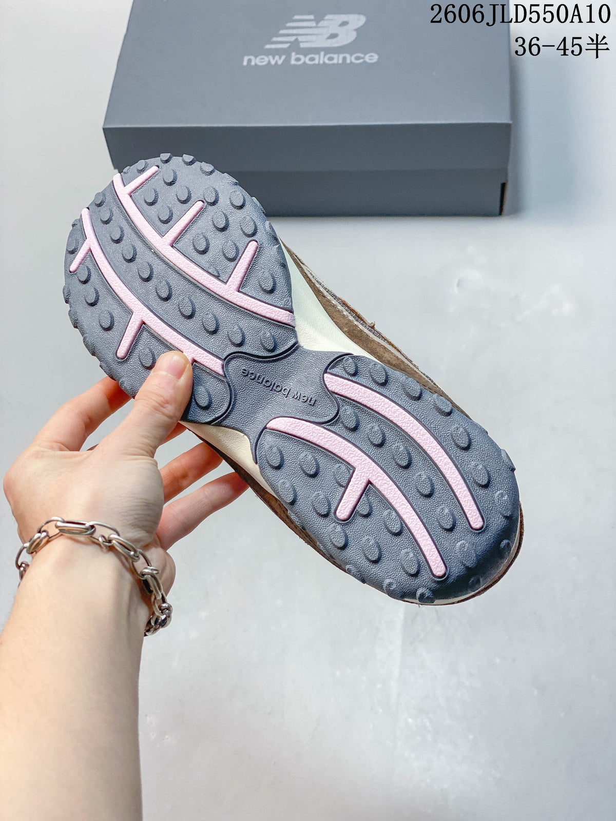 Close-up of the gray and pink outsole on a New Balance 204L sneaker