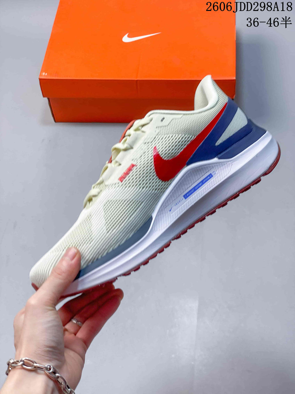 Side view of the cream mesh running shoe with a red swoosh and blue heel accents