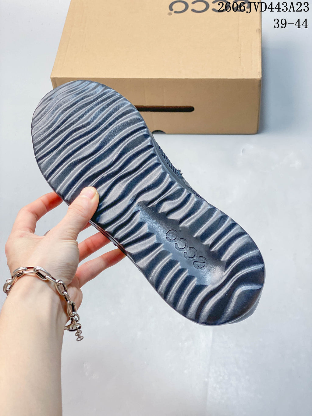 Underside of a navy sneaker showing the ridged outsole