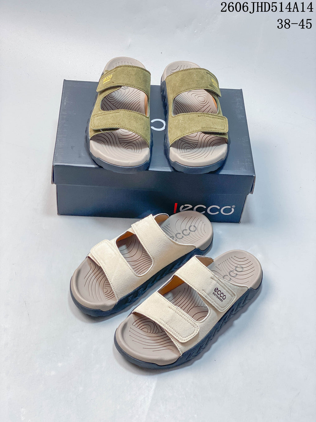 Olive green and cream two-strap sandals displayed together with their box.
