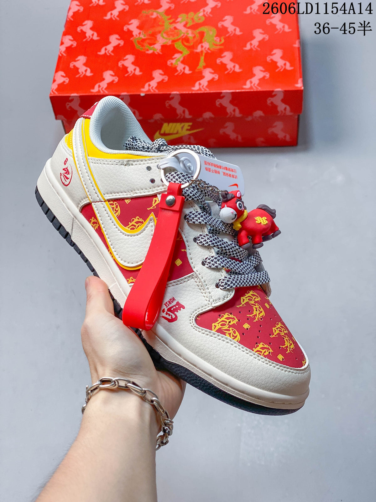 Cream Nike SB Dunk Low with red and yellow patterned panels, contrasting laces, and a horse charm