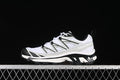 Side view of white, metal, and black Salomon XT-6 Expanse sneakers against a dark background.