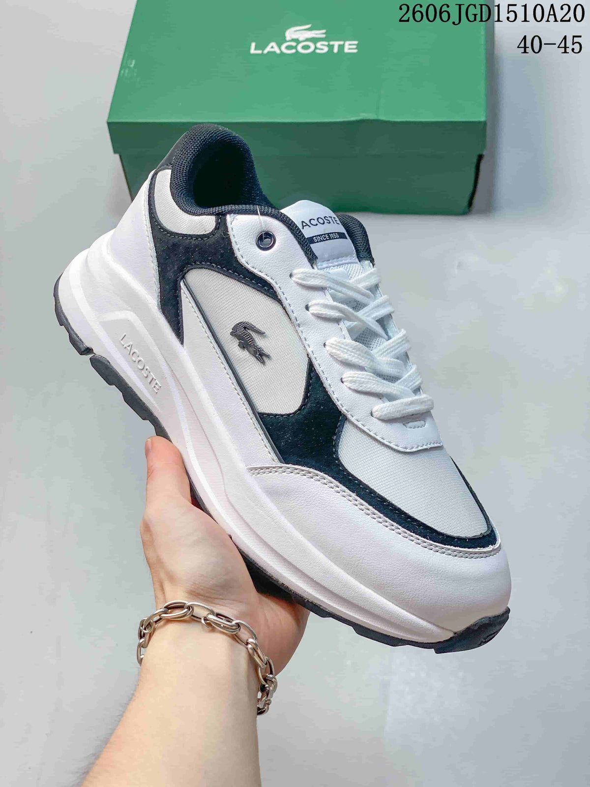 White and navy Lacoste low-top sneaker with layered panels and a chunky sole