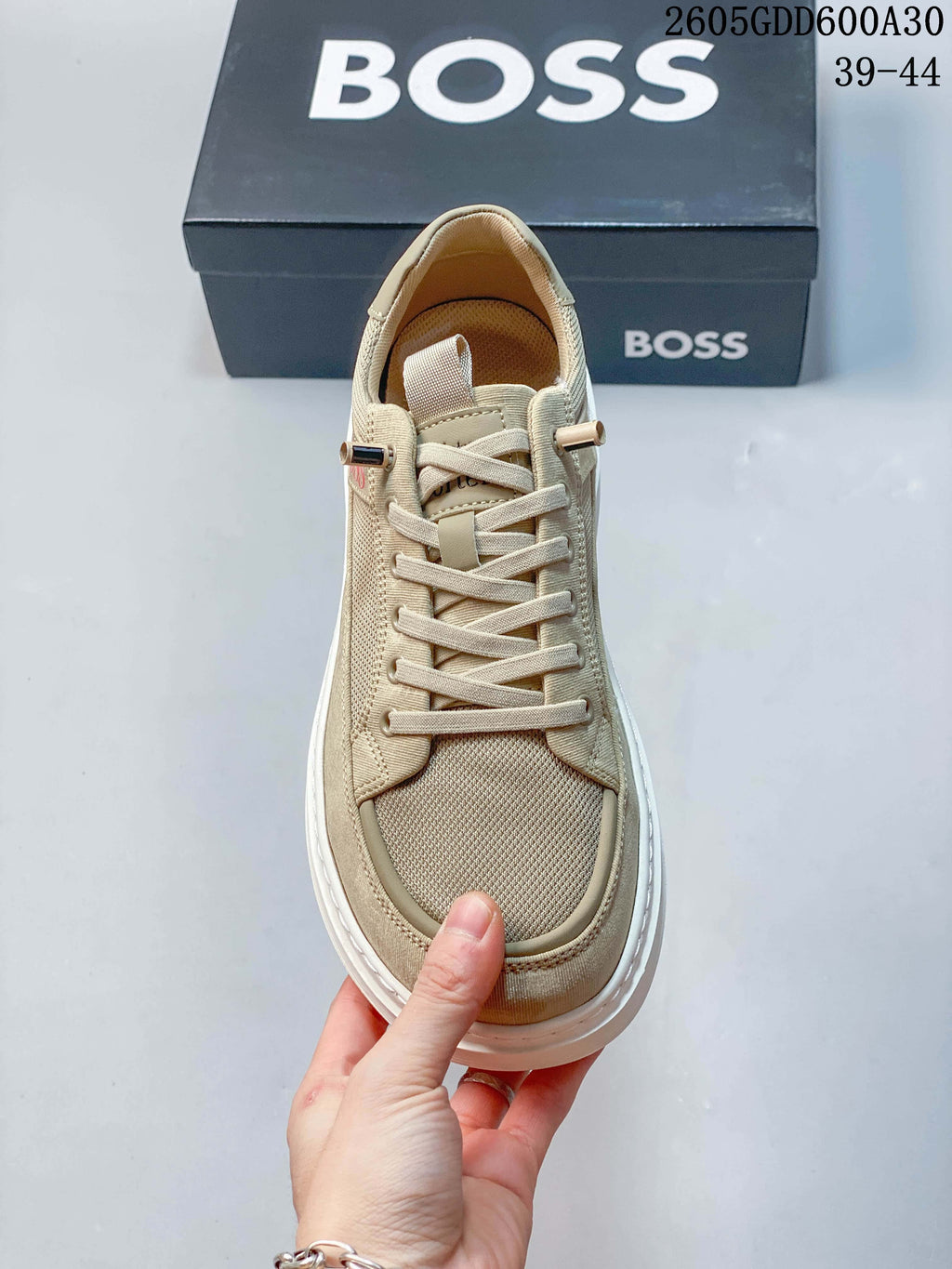Front view of the beige lace-up sneaker with textured toe panel