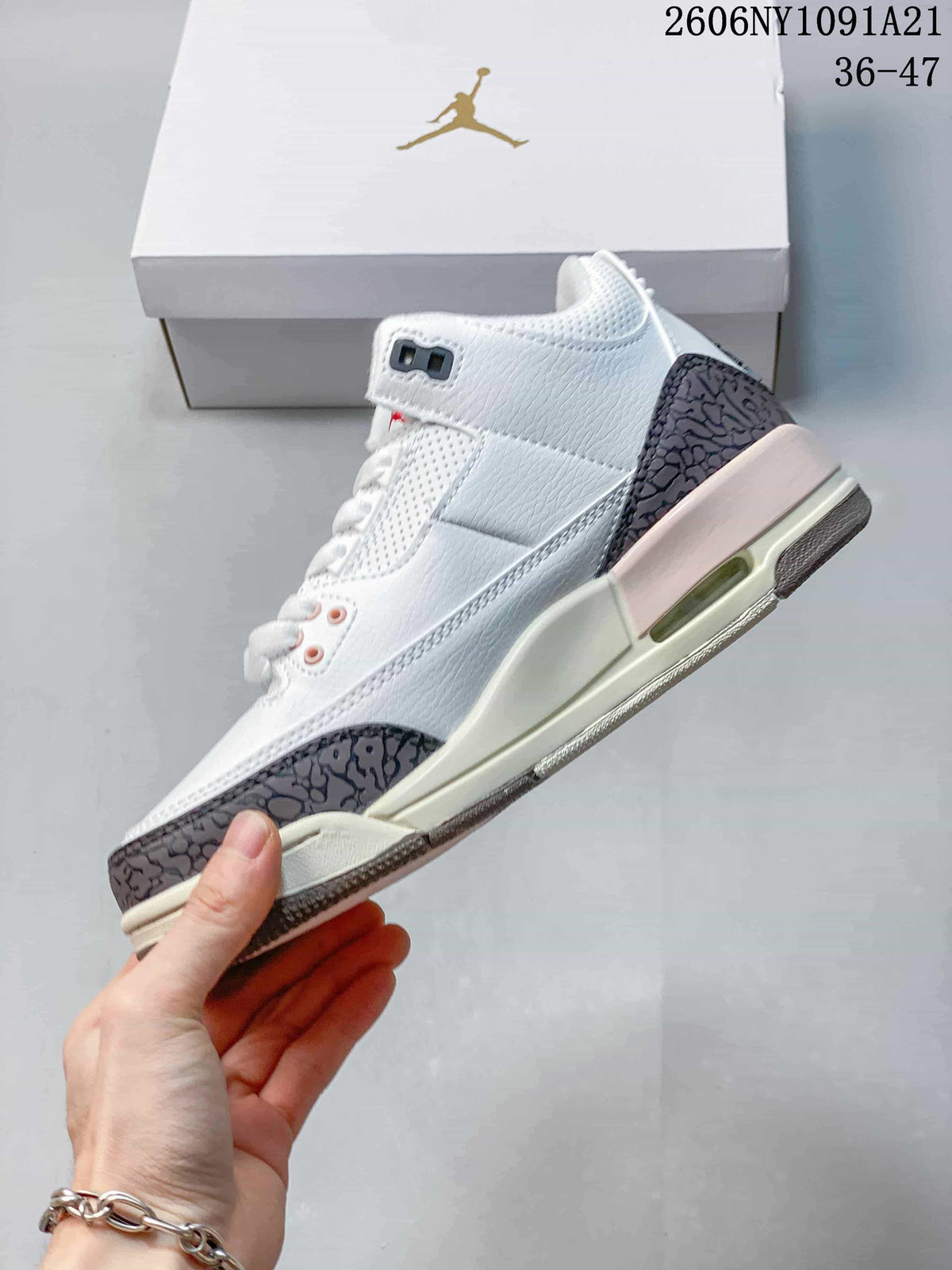 Side view of the white mid-top sneaker with patterned overlays and pale pink midsole accent