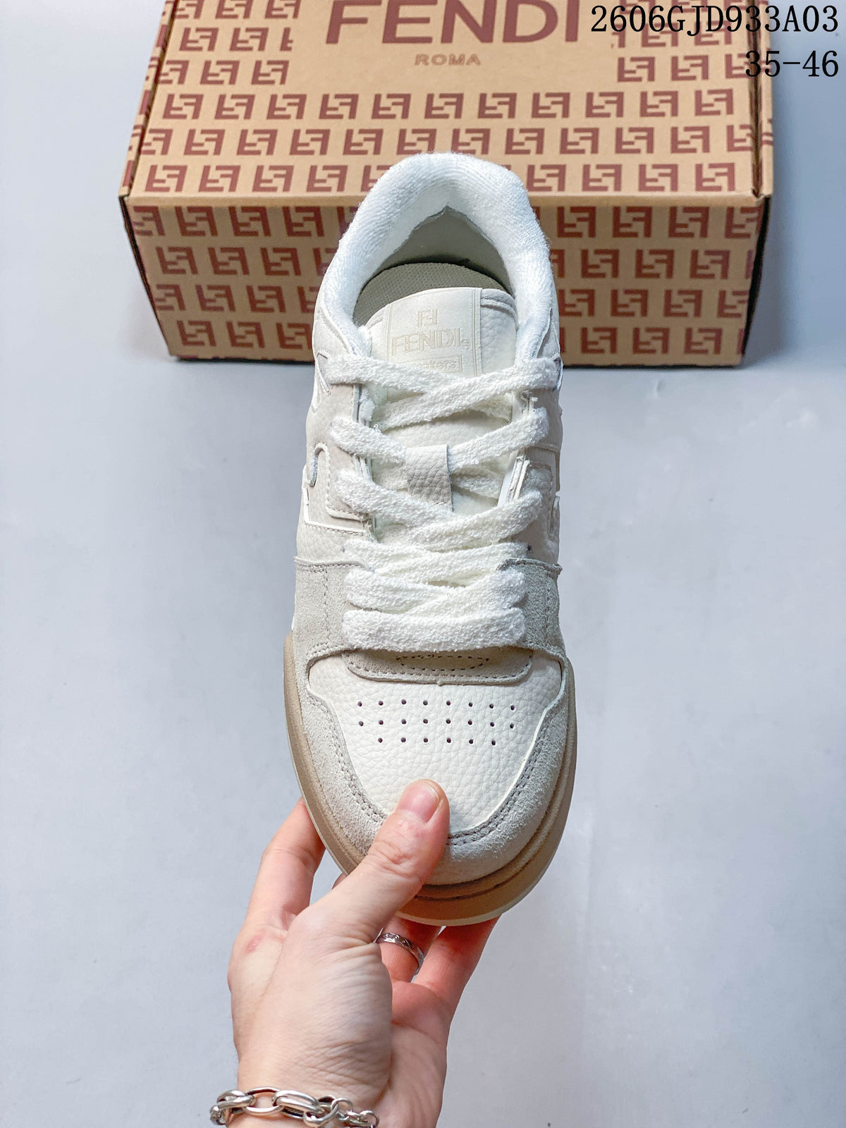 Top view of a white lace-up sneaker with a perforated toe panel; image overlay shows 2606GJD933A03 and sizes 35–46.