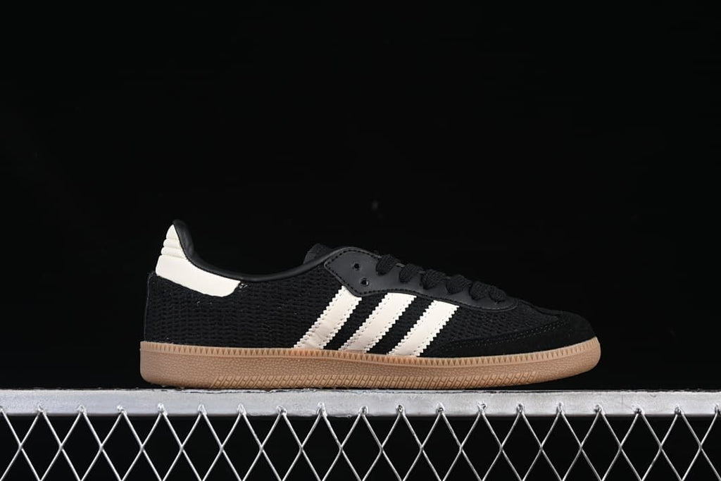 Side profile of a black Samba OG sneaker with white stripes and gum-colored outsole