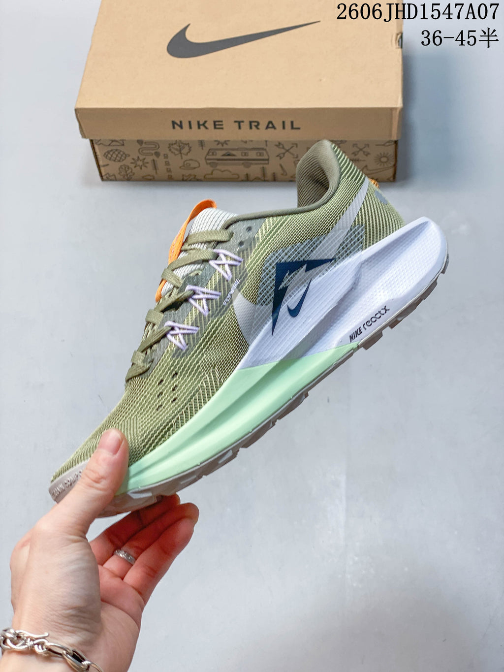 Side view of the olive green trail shoe with contrasting accents and ReactX midsole marking.