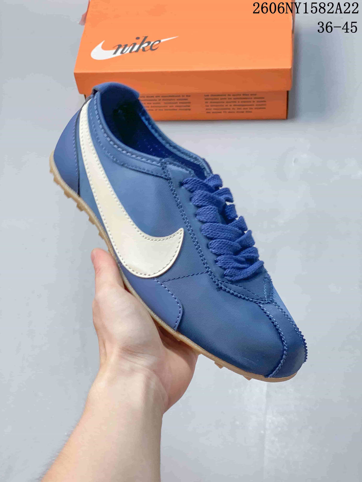 Close view of a blue Nike low-top sneaker with a light-colored Swoosh and textured outsole
