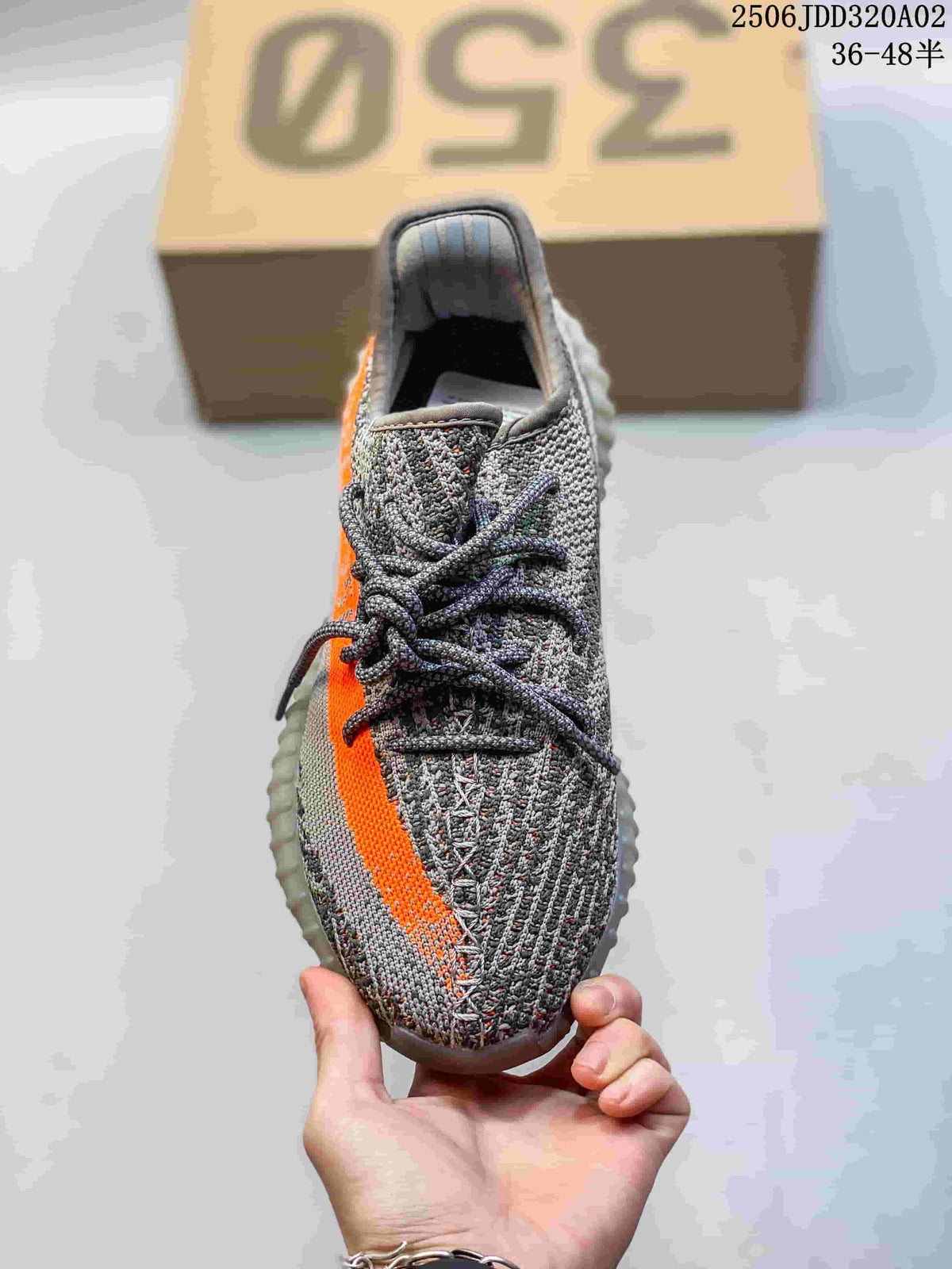 Top-down view of the gray knit sneaker, dark laces, and orange side stripe.