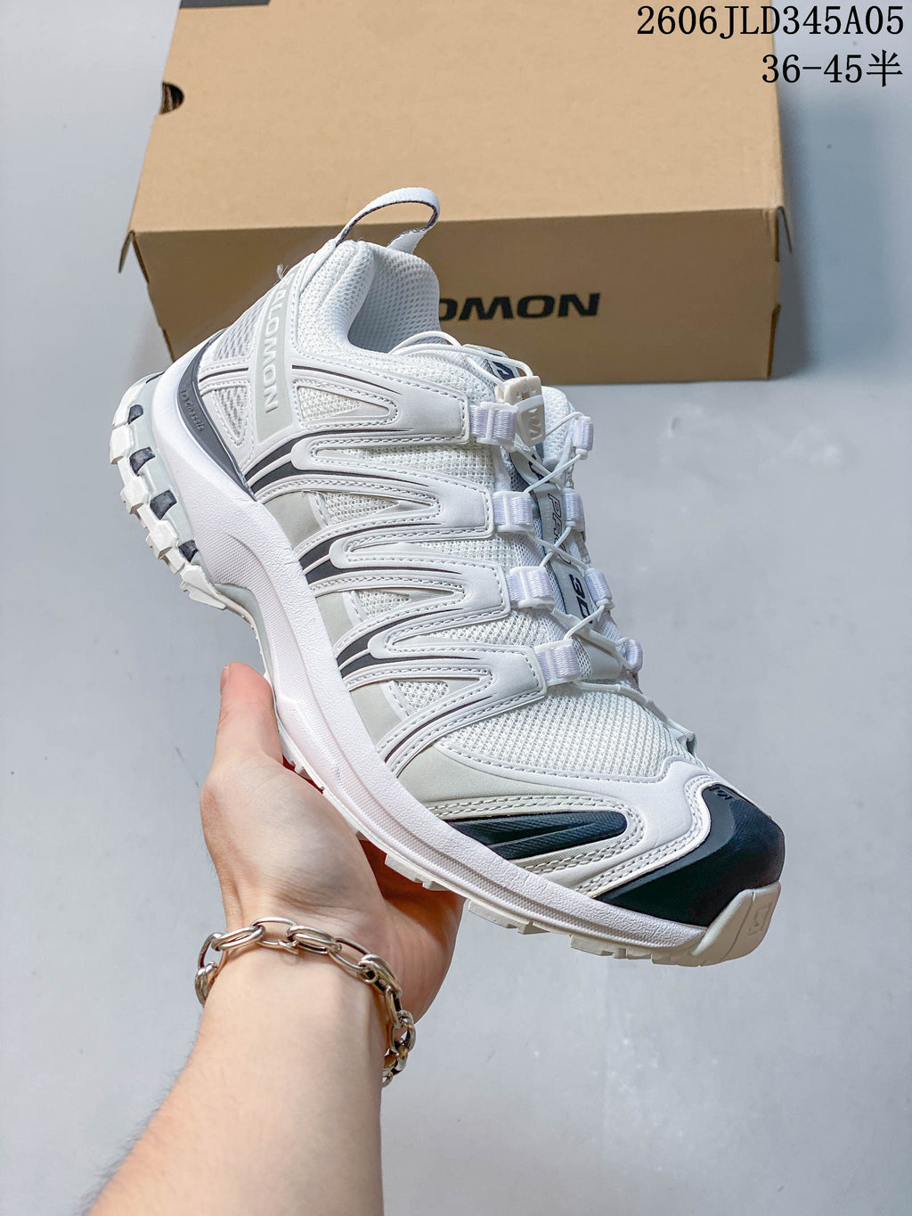 Angled side view of the white and navy Salomon XT-3D shoe