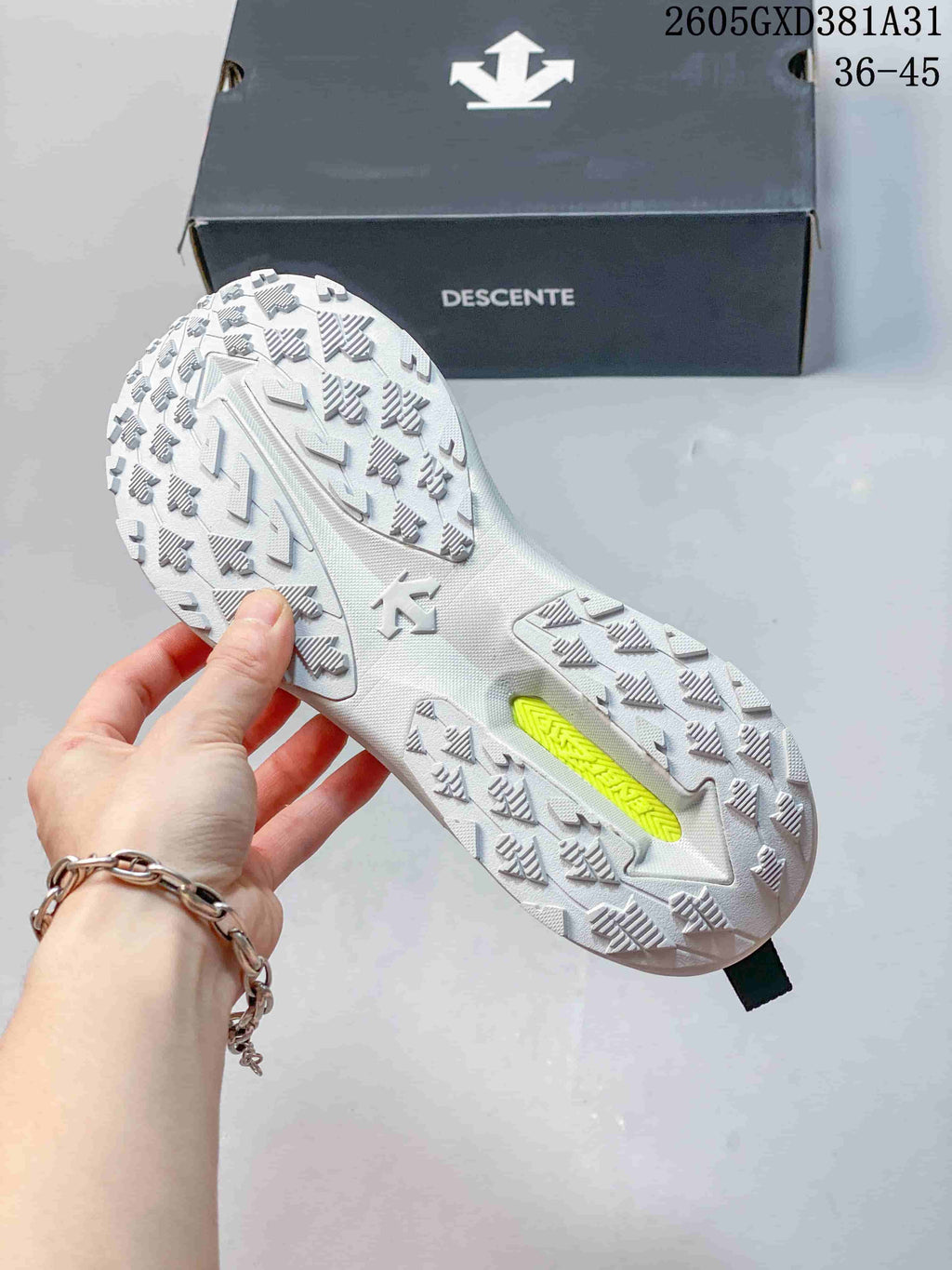 Close-up of the patterned outsole on a white Descente sneaker
