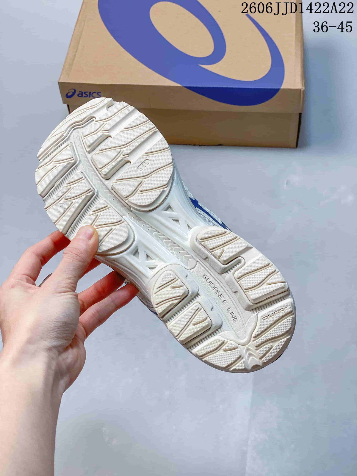 Close-up of the patterned outsole on a white ASICS shoe