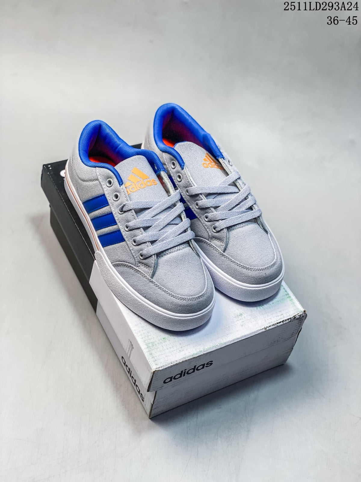 Pair of gray Adidas GVP Canvas STR sneakers with blue stripes and orange accents on a shoebox