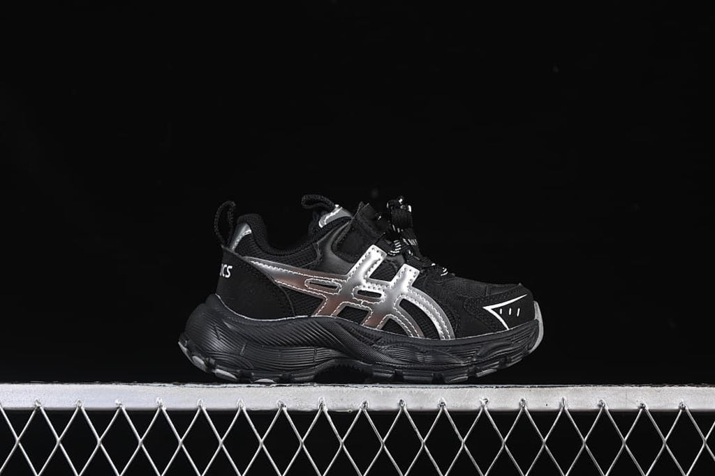 Side profile of a black sneaker with silver accents and a chunky outsole.