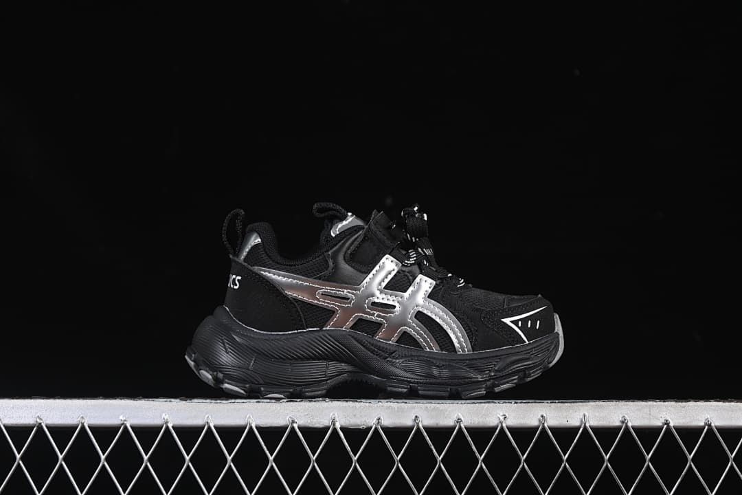 Side profile of a black sneaker with silver accents and a chunky outsole.
