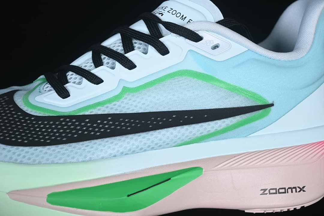 Close-up of the side Swoosh, green trim, black laces, and midsole.