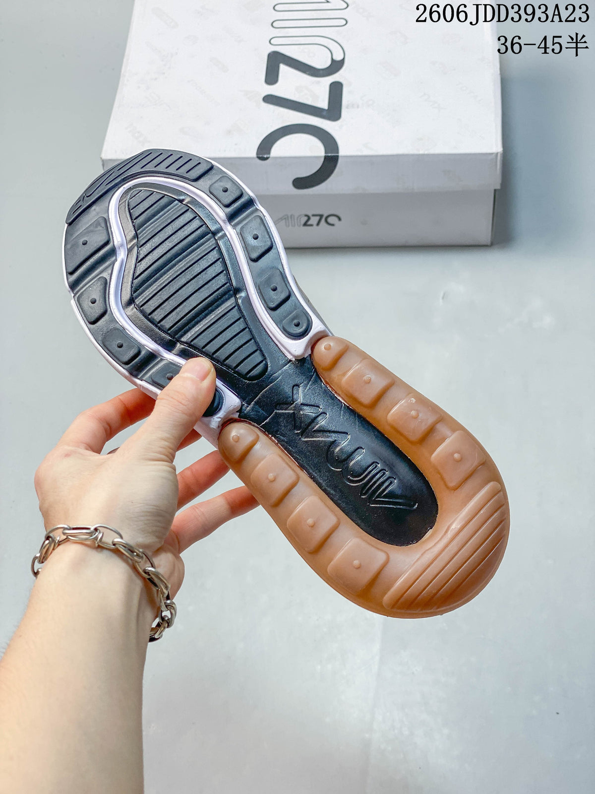 Underside of a Nike Air Max 270 sneaker showing its dark tread and amber-colored heel unit.