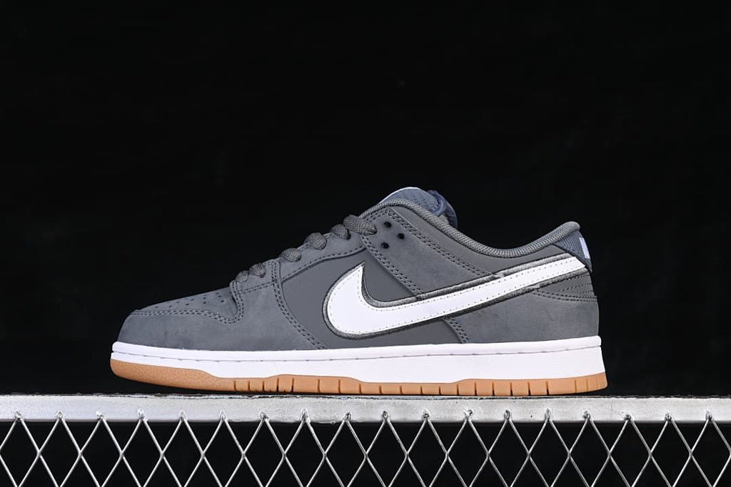 Side view of the Nike SB Dunk Low in gray, white, and gum colors.