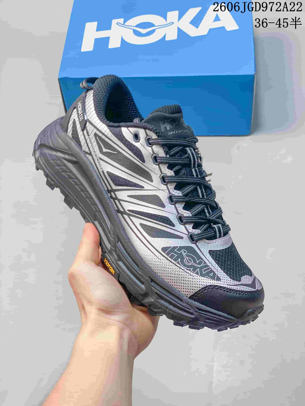 Side view of a dark navy and silver HOKA Mafate Speed 4 Lite shoe with a patterned upper and rugged tread.