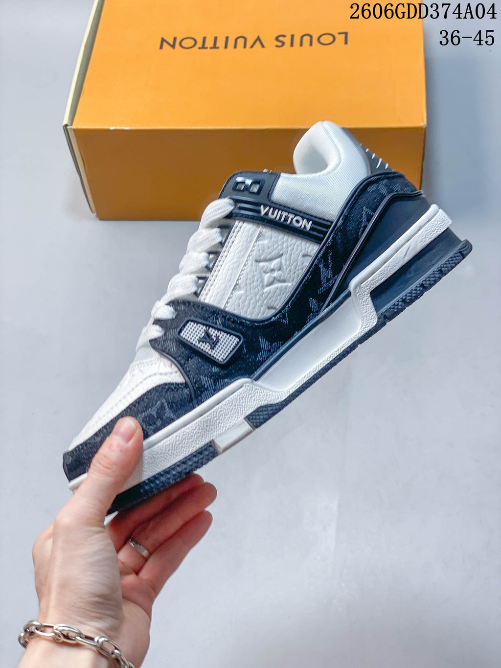 Side view of a white and navy Louis Vuitton Trainer low-top sneaker.