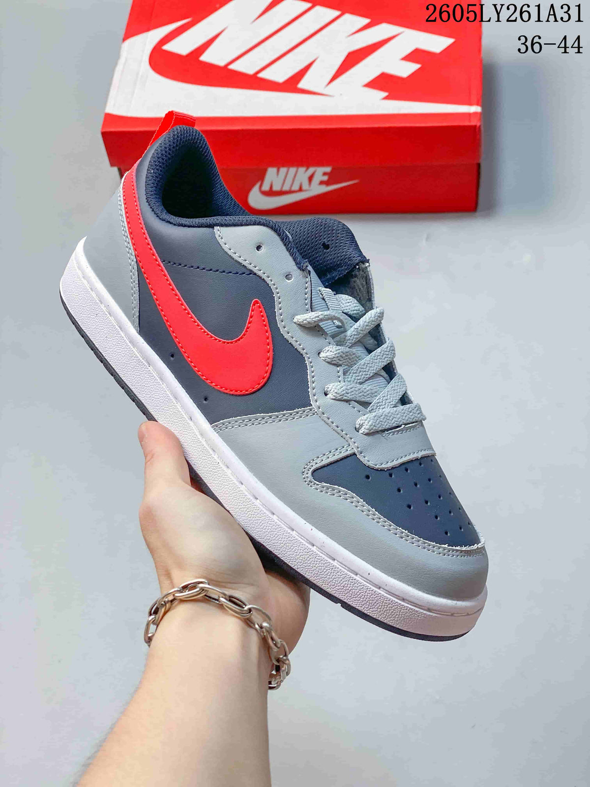 Angled side view of the navy, gray, red, and white low-top sneaker