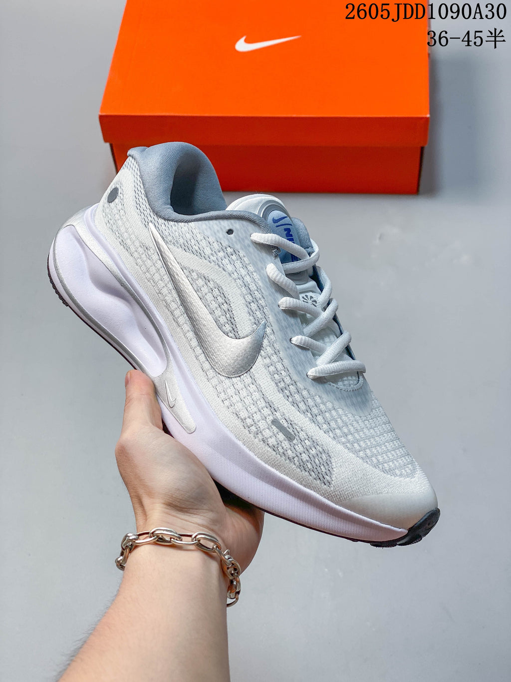 White Nike Journey Run running shoe with neon yellow accents and a patterned upper.