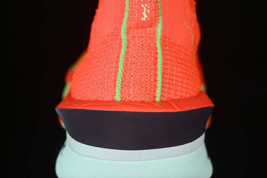 Rear view showing the knit heel, lime trim and pale mint midsole.
