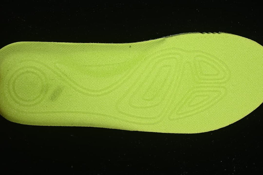 Bright lime-colored insole viewed from the underside