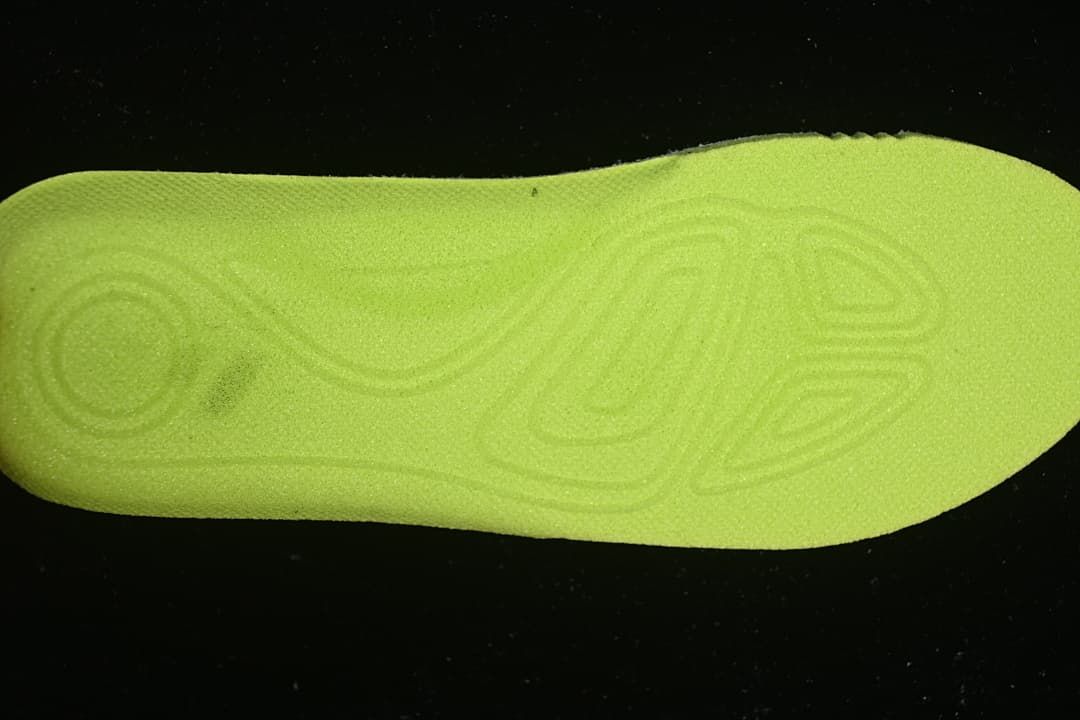 Bright lime-colored insole viewed from the underside