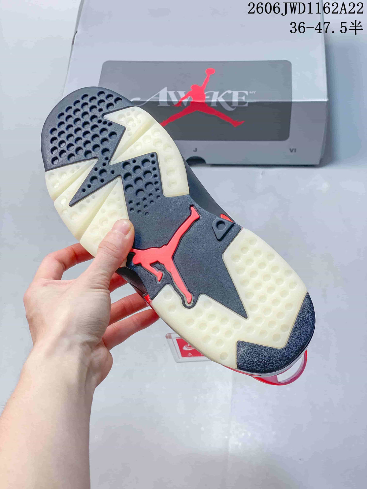 Underside of the Air Jordan 6 showing a dark and pale outsole with red detailing