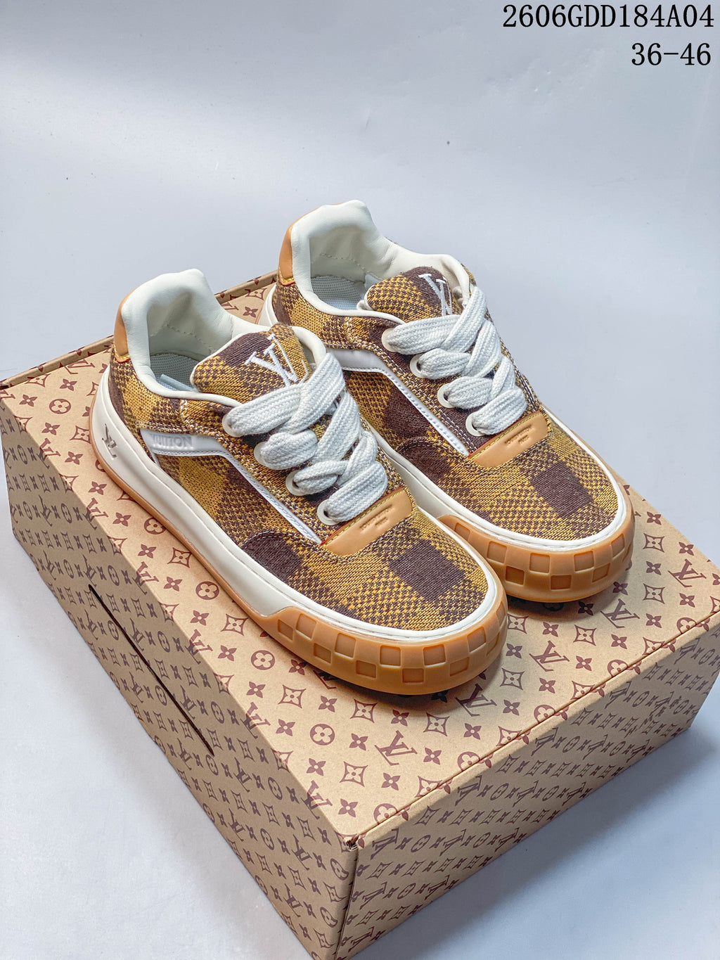 Pair of brown and mustard check-pattern low-top sneakers with white laces and tan accents