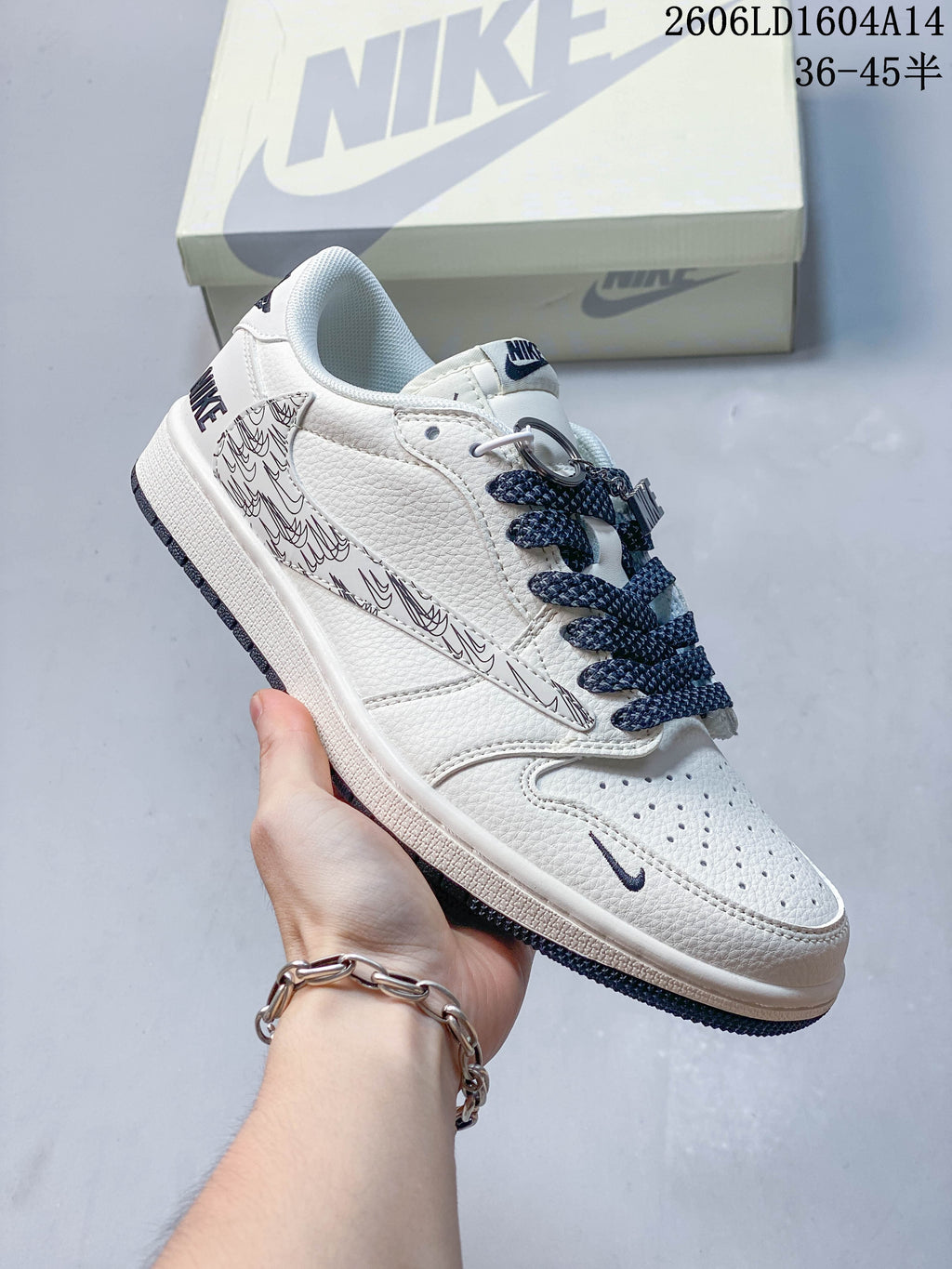 Side view of a white sneaker with navy laces and an all-over line-patterned side panel